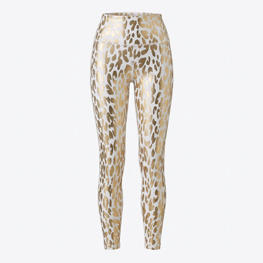 A pair of high-waist leopard print leggings in gold and white, paired with white sneakers.